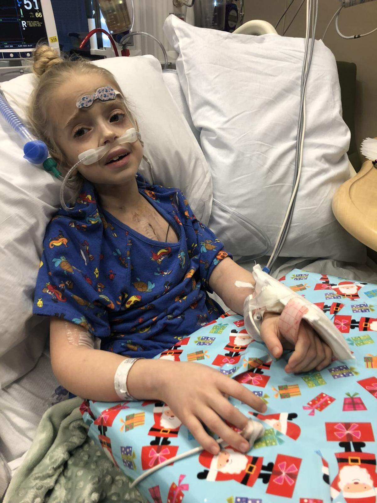 Riley Robinson, 8, sits up in bed one day during her hospital stay. The ventricular assist devices she had in her chest, which connected to a large machine, helped pump blood throughout her body.