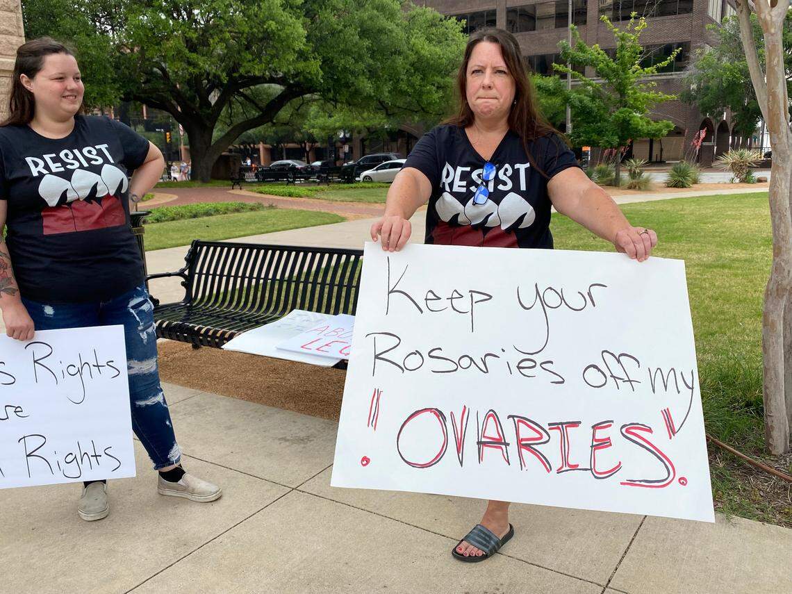 Lisa Keegan-Bishop holds a sign saying ‘Keep your rosaries off my ovaries!’