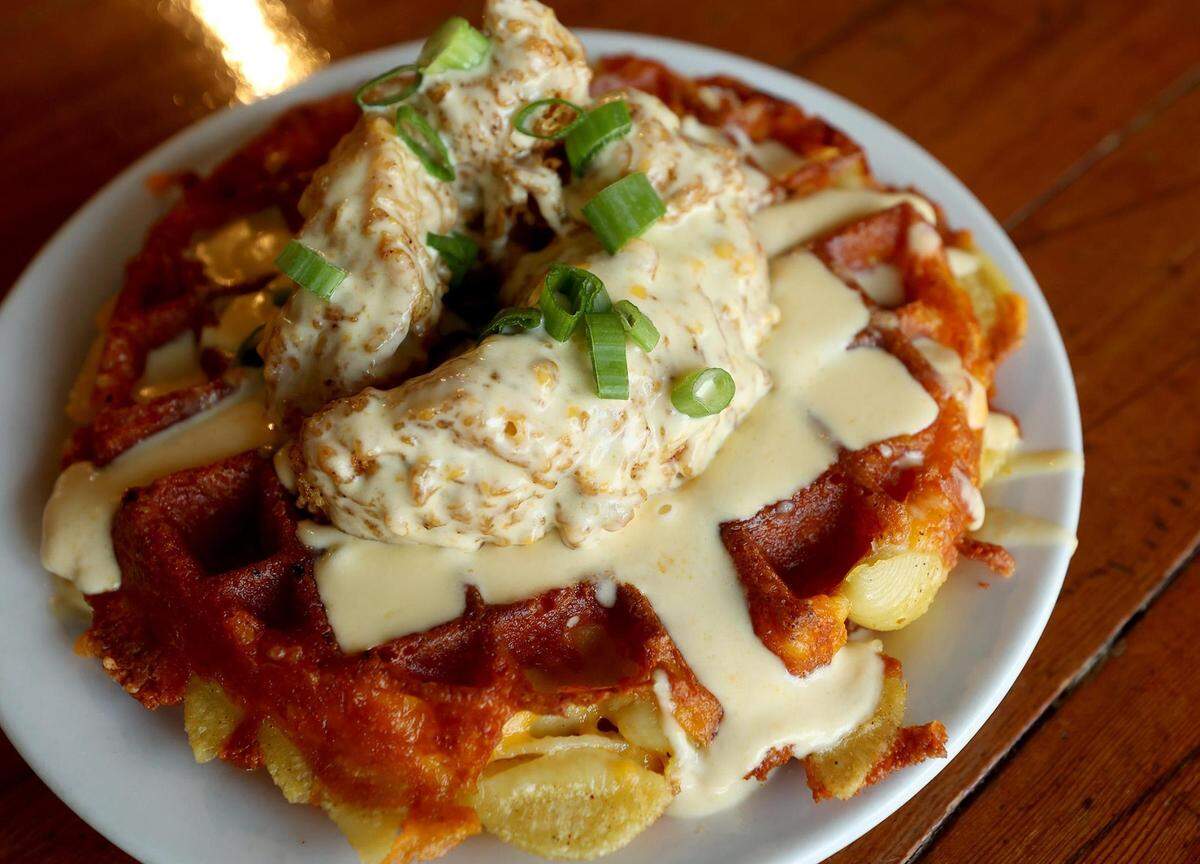 The chicken & mac and cheese waffle at Brewed features seasoned chicken with a macaroni and five-cheese waffle with cheese sauce.