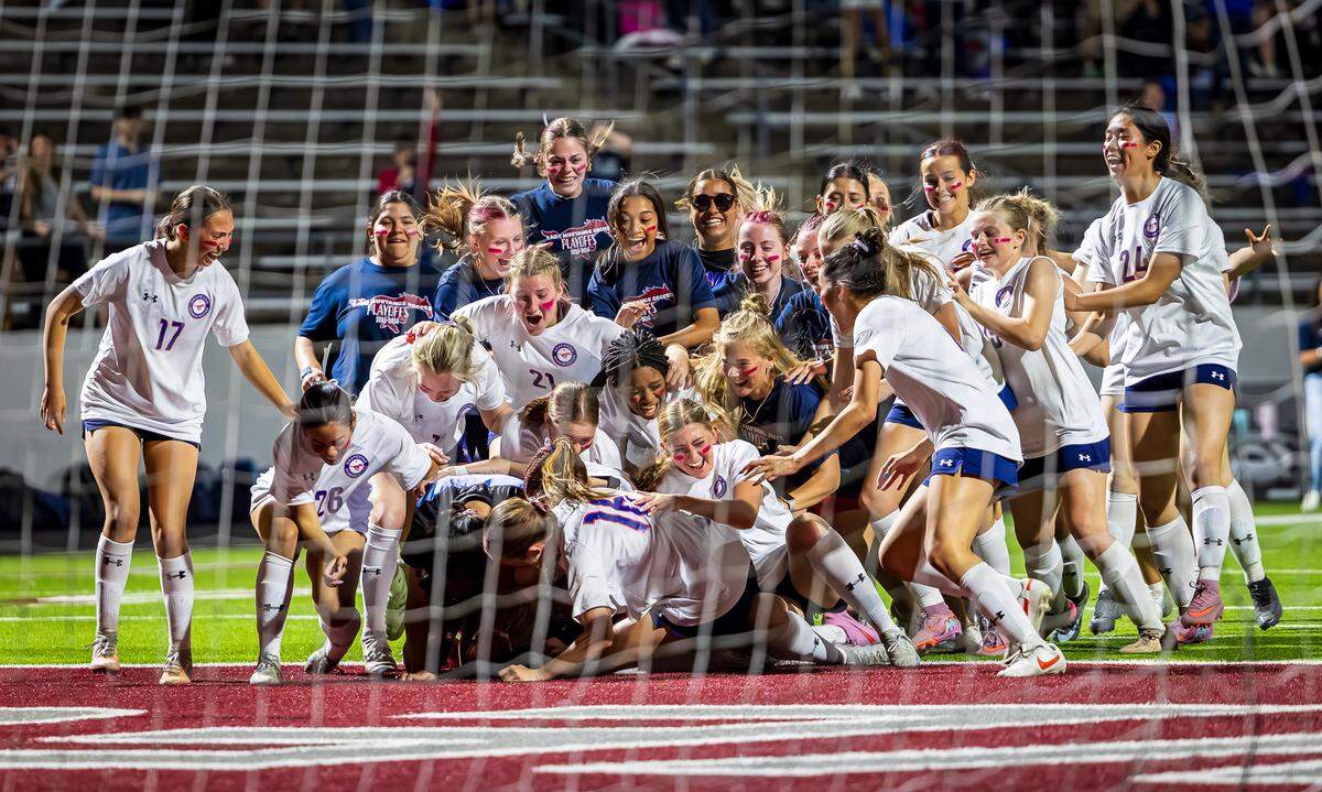 The Grapevine girls soccer team piles on goalkeeper Brooke Bereuter in celebration after defeating Argyle 1-0 (SO 4-3) in the Class 5A Division 2 Region 1 Final on Tuesday, March 31, 2026, at Northwest ISD Stadium in Justin, Texas.