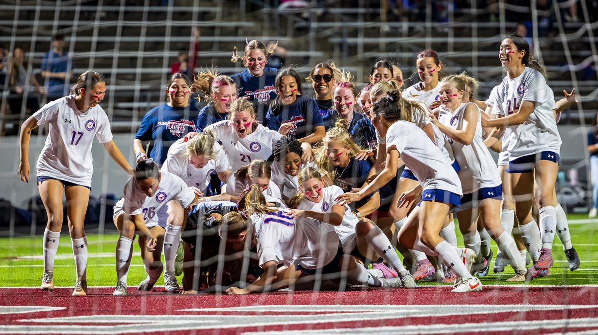 The Grapevine girls soccer team piles on goalkeeper Brooke Bereuter in celebration after defeating Argyle 1-0 (SO 4-3) in the Class 5A Division 2 Region 1 Final on Tuesday, March 31, 2026, at Northwest ISD Stadium in Justin, Texas.