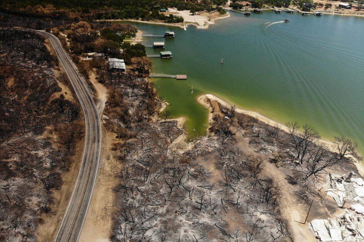 Charred trees and remains of a structure are left after a wildfire along FM 1148 on Monday, July 25, 2022, near Possum Kingdom Lake.