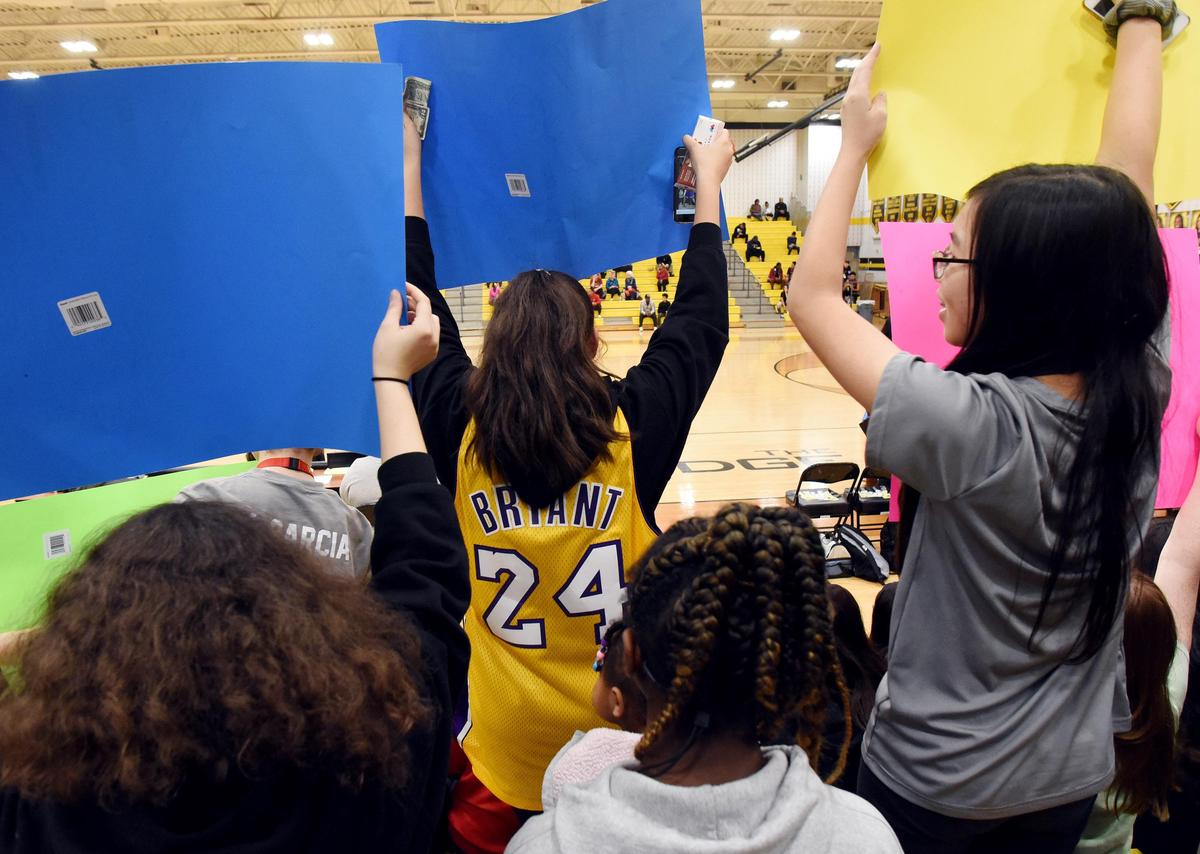 Emily Ortega, center wears a Lakers Kobe Bryant jersy as she holds signs and cheers the Fossil Ridge varsity basketball girls as they play Central tribute during Tuesday’s January 28, 2020 at Fossil Ridge High School in Keller. Texas. Special/Bob Haynes