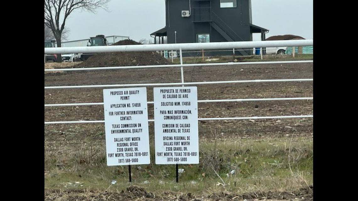 A sign showing a government notice in front of a field