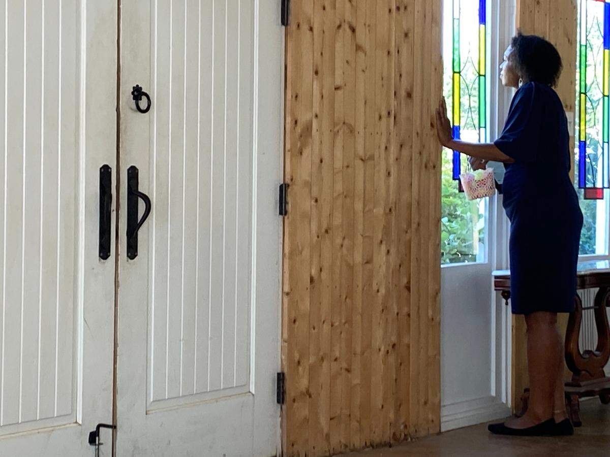 Jasmyn Richardson, who officiated weddings for three LGBTQ couples in North Texas on Sunday, looks out a window as she holds a container of flower petals.