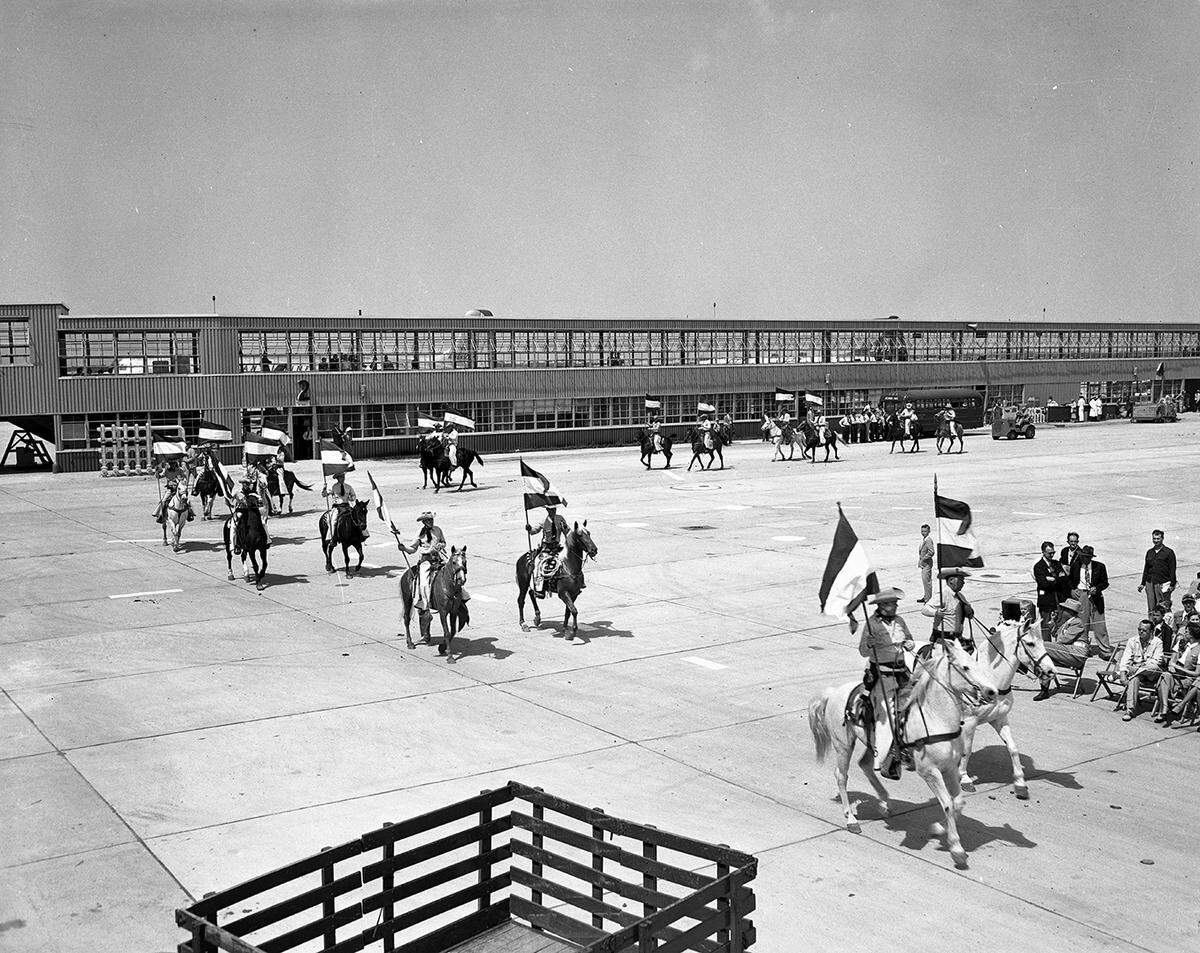 April 1953: A group of cowboys ride horses outside the terminal at the grand opening of Greater Fort Worth International Airport.