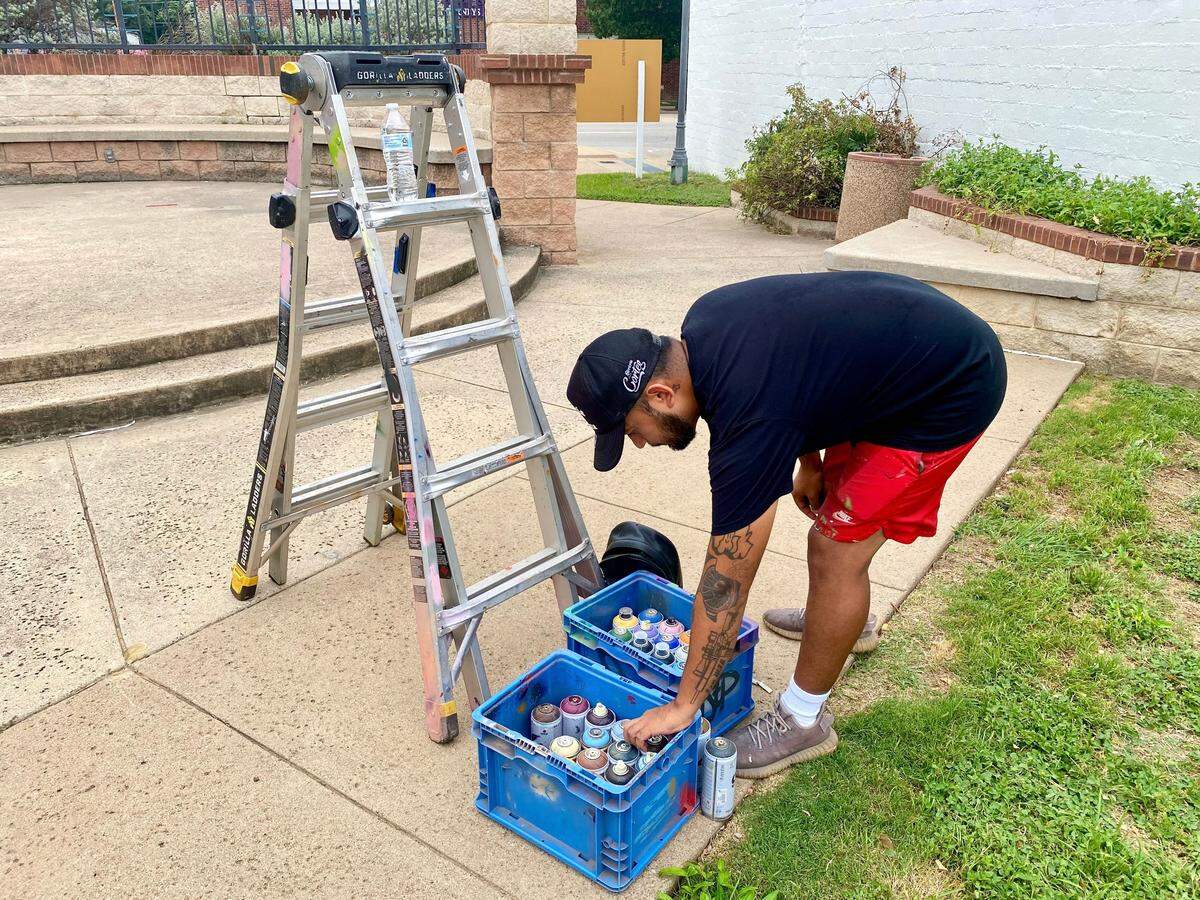 Juan Velasquez gathering his painting supplies.