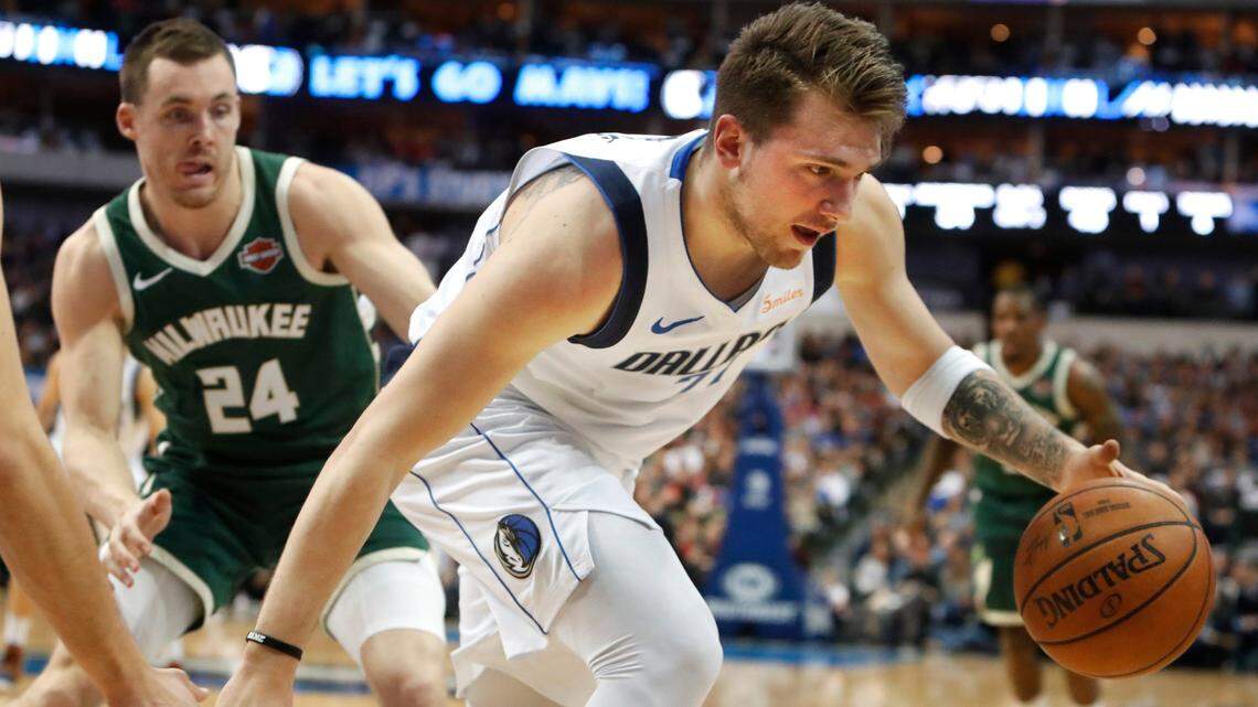Dallas Mavericks forward Luka Doncic (77) dribbles past Milwaukee Bucks guard Pat Connaughton (24) during the first half of an NBA basketball game in Dallas, Friday, Feb. 8, 2019. (AP Photo/LM Otero)