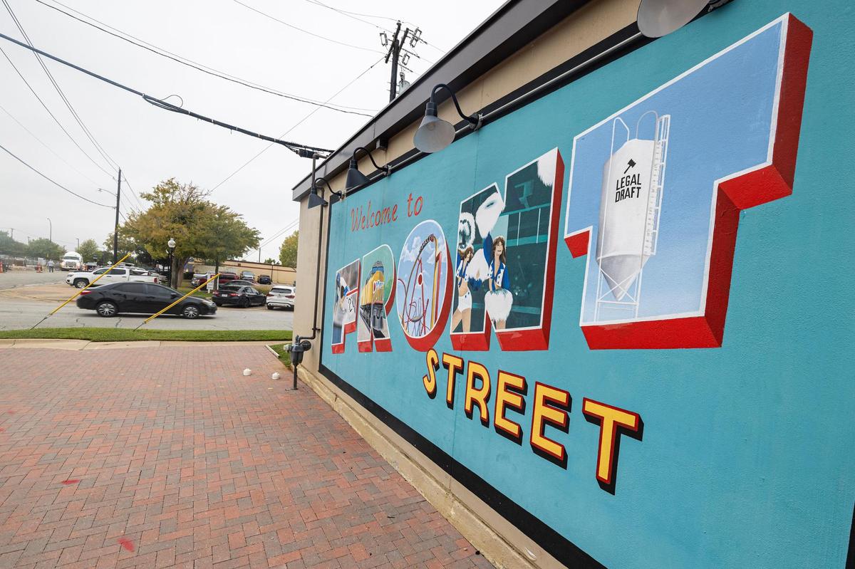 A car drives past a mural painted on one of the buildings at the intersection of N Mesquite Street and E Front Street, a new growth hub in downtown Arlington. Businesses and city leaders are optimistic about its future.