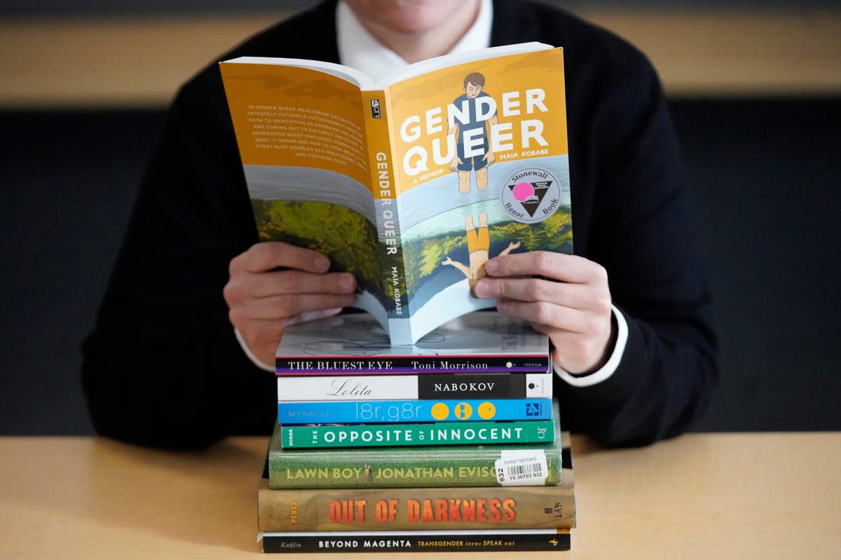 Amanda Darrow, director of youth, family and education programs at the Utah Pride Center, poses with books that have been the subject of complaints from parents in Salt Lake City. (AP Photo/Rick Bowmer)