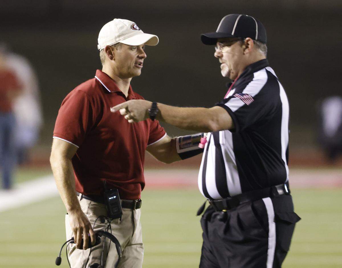 Saginaw head coach Mike Dewitt talks to head linesman Drew Brock during the first half of a UIL football game between Saginaw and Paschal at Farrington Field in Fort Worth, Texas, Thursday, October, 16, 2025.