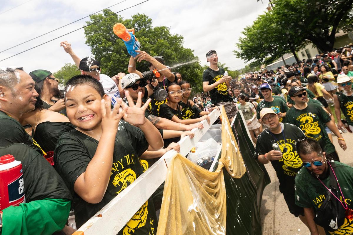 Festival attendees pack the streets and party on their parade float during the Lao New Year parade on the third day of the Lao New Year festival at Wat Lao Thepnimith Temple in Saginaw on Sunday, April 27, 2025.