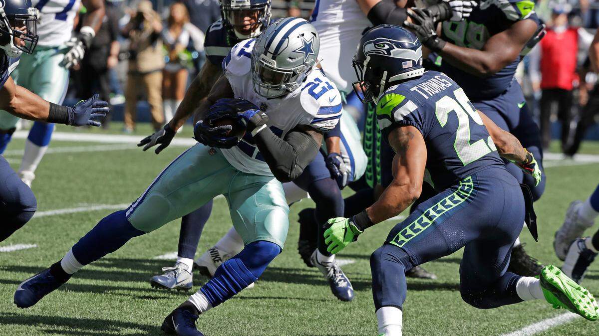 Dallas Cowboys running back Ezekiel Elliott (21) is tackled by Seattle Seahawks free safety Earl Thomas, right, during the first half of an NFL football game, Sunday, Sept. 23, 2018, in Seattle.