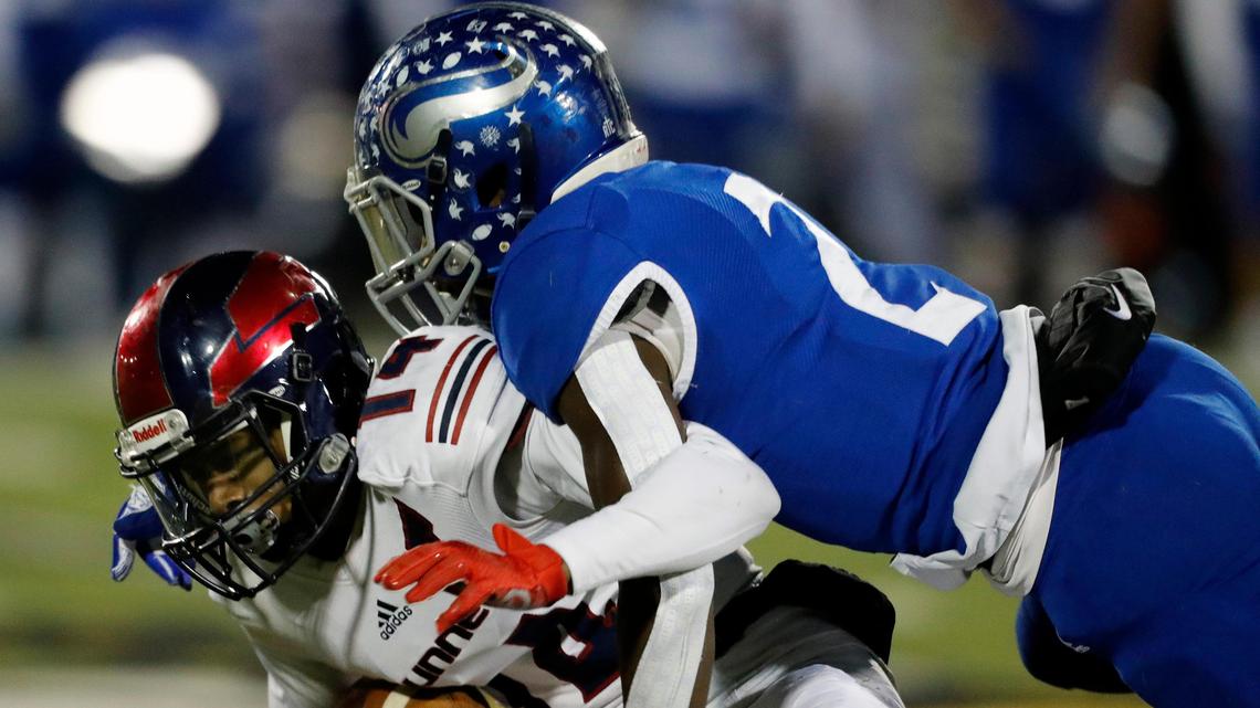 Bishop Dunne wide receiver Brian Fleming (14) is dropped by Nolan Catholic corner back Devin Thomas (2) after a mid-field catch in the first half of a TAPPS division I high school football playoff game at the Doskocil Stadiuim in Fort Worth, Texas, Saturday, Nov. 16, 2019. Nolan led 24-7 at the half. (Special to the Star-Telegram Bob Booth)