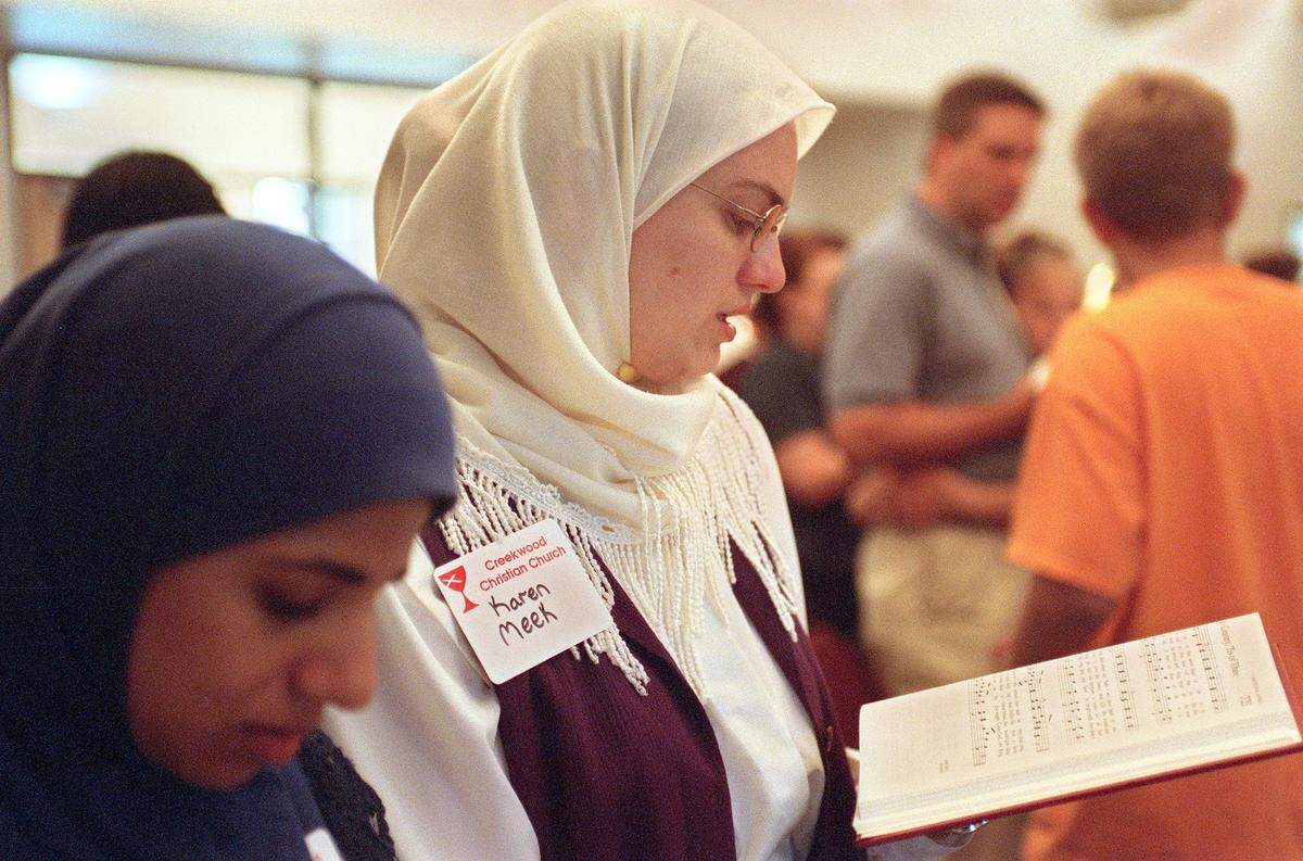 Asma Khan, left, and Karen Meek of the Islamic Association of Lewisville and Flowermound pray during an Interfaith Service of Prayer on Sept. 11, 2001, at Creekwood Christian Church in Flower Mound.