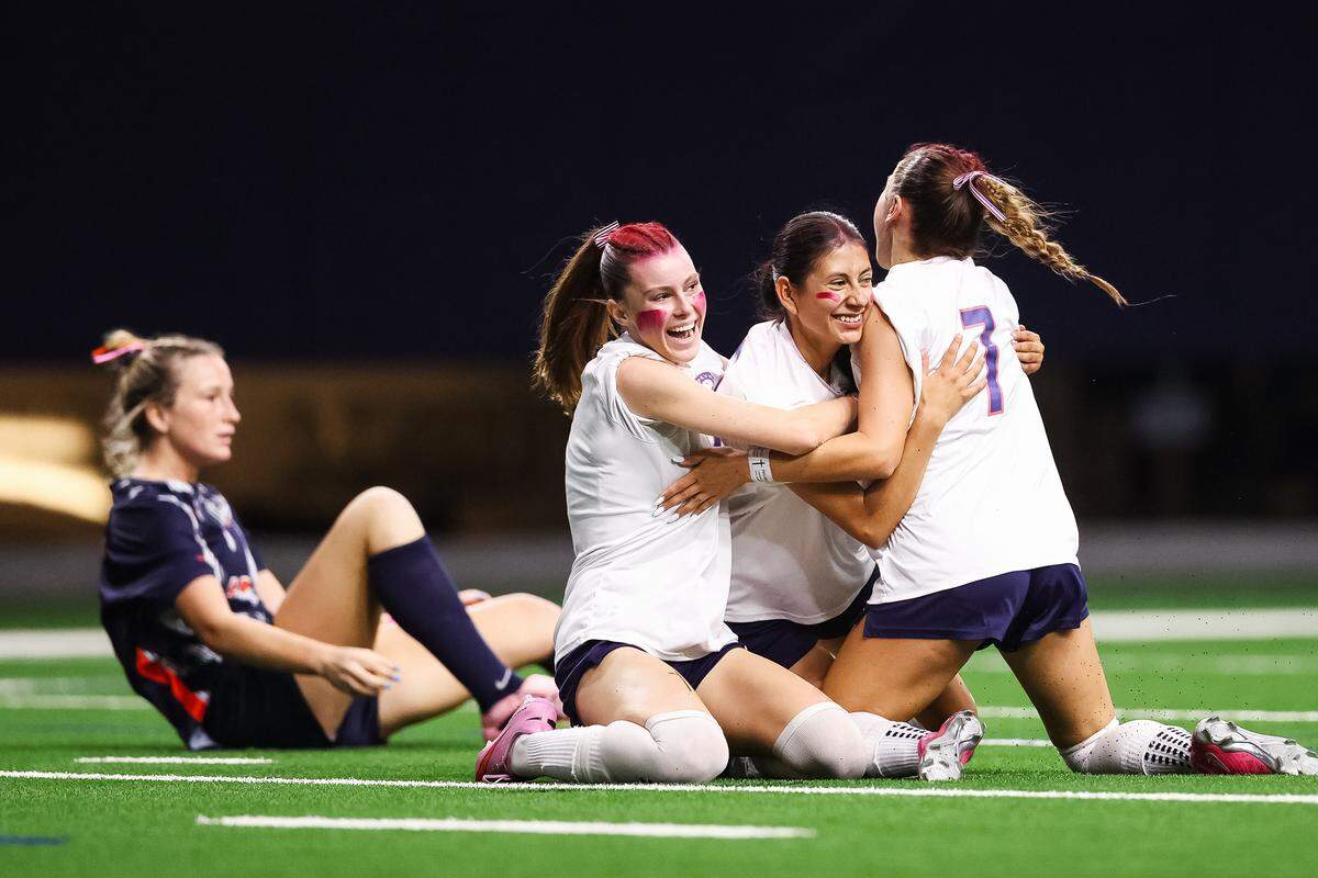 Grapevine forward Paola Granados (28) is hugged by two of her teammates after scoring a goal against Frisco Wakeland in a Class 5A Division II UIL girls soccer state semifinal at the Ford Center on April 3, 2026 in Frisco, Texas.