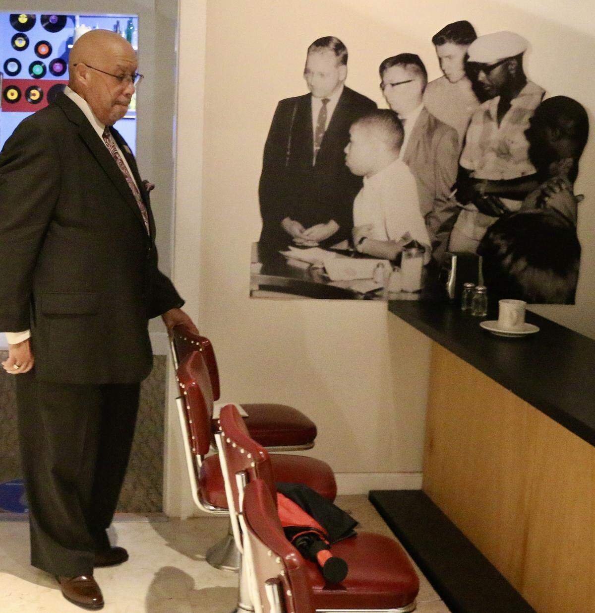 Rodney Hurst visits a replica of the lunch counter where he took part in a peaceful demonstration to protest the discrimination faced by Blacks, at a display at at the Ritz Theater, on Friday, Oct. 23, 2020, in Jacksonville, Fla. In the background is a blow up of a photo taken in 1960 when he was 16. After leaving the lunch counter in downtown Jacksonville as a teen, a mob of whites began indiscriminately clubbing African Americans with baseball bats and ax handles during a day now remembered as Ax Handle Saturday.