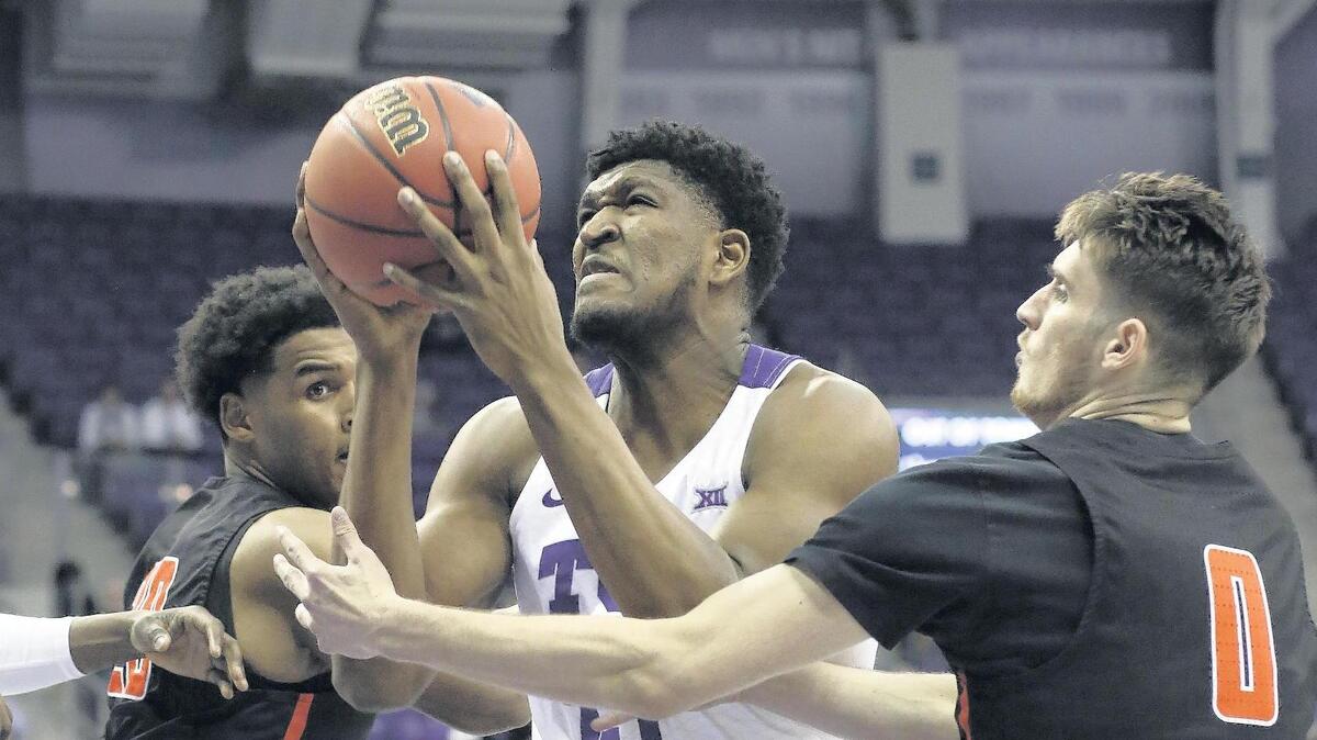 TCU freshman center Kevin Samuel (21) shoots between Sam Houston State forward Kai Mitchell (20) and guard Albert Almanza (0) in the first half of Wednesday’s first-round NIT game in Fort Worth. Samuel finished with 11 points and six rebounds in the Horned Frogs’ 82-69 victory.