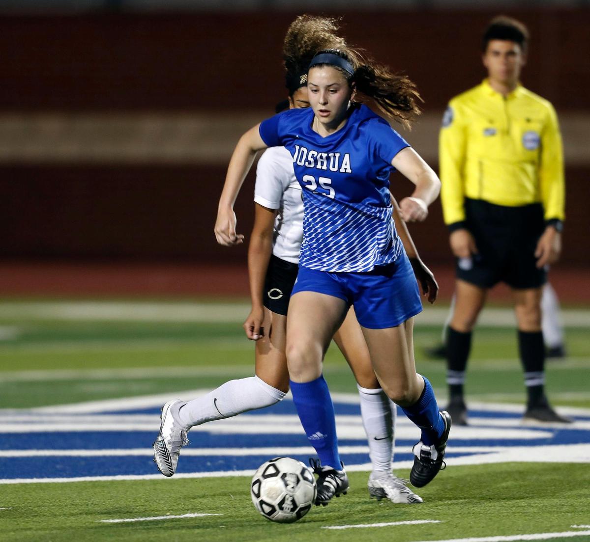 Joshua’s Graycen Rasmussen (25) brings the ball across mid pitch defended by Cleburne’s Allyson Reed (11) during a District 14-5A high school soccer game at Joshua High School in Joshua, Texas, Monday, March 08, 2021. The girls played to a scoreless game. (Special to the Star-Telegram Bob Booth)
