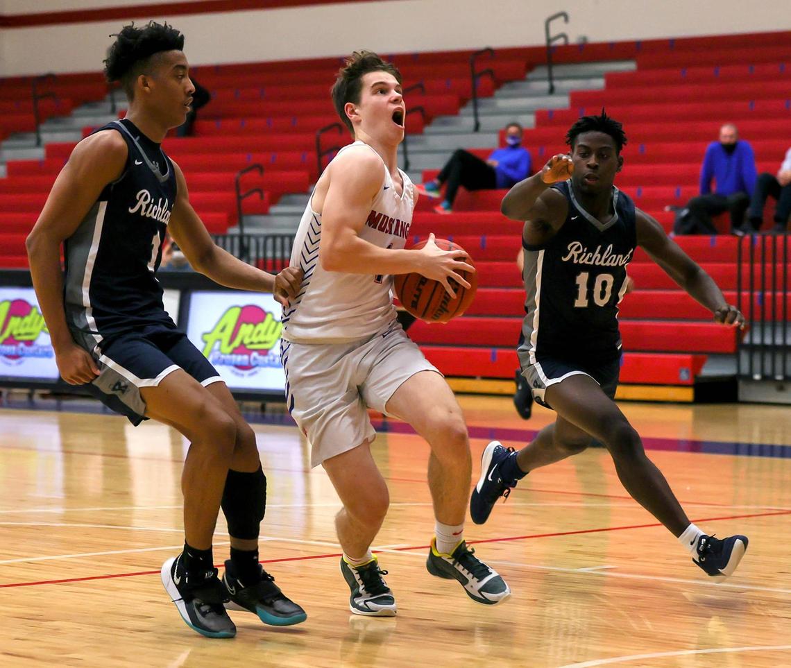 Grapevine guard Jackson Waggoner (c) tries to drive to the basket between Richland guard Jourdyn Grandberry (1) and guard Jayden Rhinehart (10) during the first half of a High School basketball game, January 25, 2021, played at Grapevine High School in Grapevine, Tx. (Steve Nurenberg Special to the Star-Telegram)