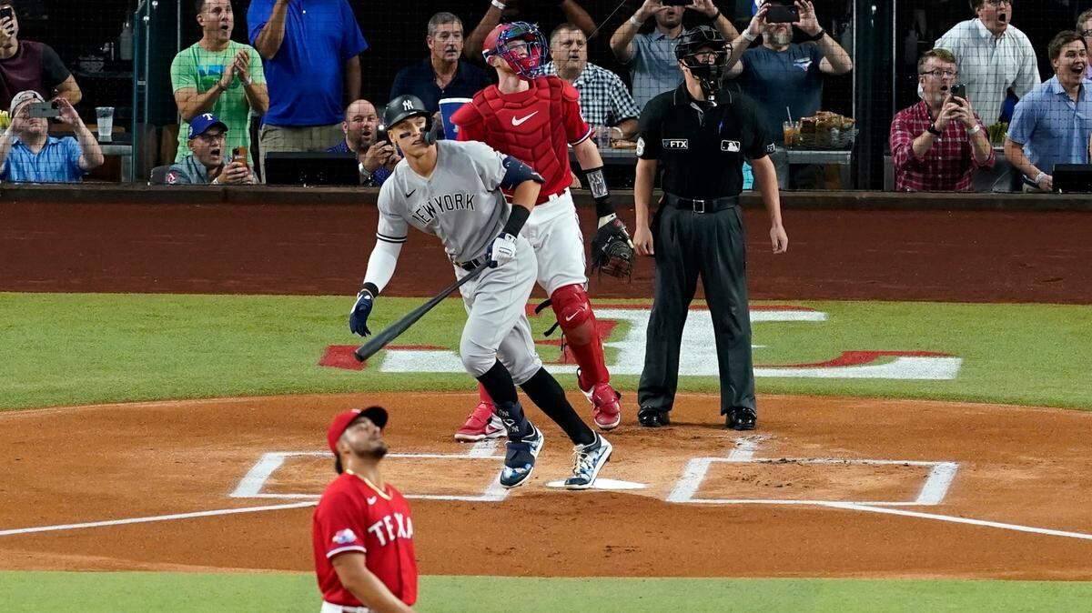 New York Yankees’ Aaron Judge watches his a solo home run, his 62nd of the season, off of Texas Rangers starting pitcher Jesus Tinoco (63) as catcher Sam Huff and umpire Randy Rosenberg look on in the first inning of the second baseball game of a doubleheader in Arlington, Texas, Tuesday, Oct. 4, 2022. With the home run, Judge set the AL record for home runs in a season, passing Roger Maris.