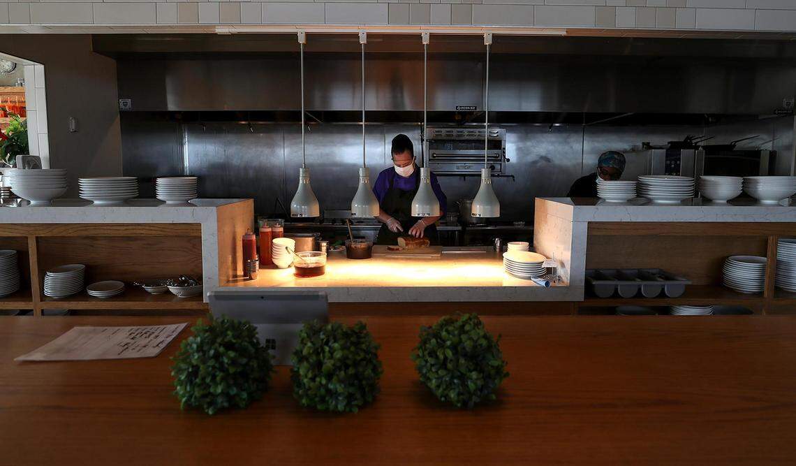 Misty Farrand, sous chef at Taste Project in Fort Worth, slices bread for an order in 2021. Taste Project is a nonprofit created to address food insecurity. The restaurant provides healthy food without a price tag, asking costumers to pay what they can afford.