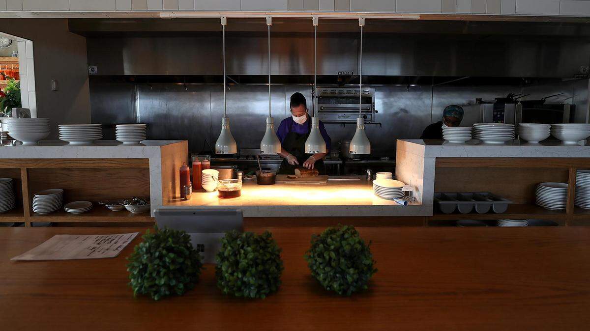 Misty Farrand, sous chef at Taste Project in Fort Worth, slices bread for an order in July 2021. The Taste Project received more than $750,000 in grant funding from Texas Health Resources.