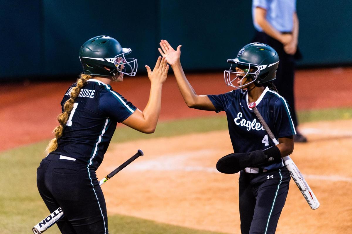 Raigan Brannon (7) and Kassidy Chance (4) high five after Chance made it home during the 6A UIL State Softball semifinal between Lake ridge and Deer Park in Austin Texas, on June 3rd, 2021.