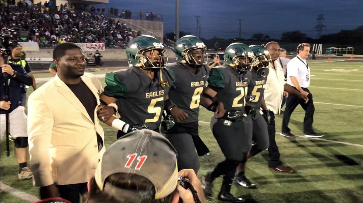 Wearing his NFL Hall of Fame jacket, LaDainian Tomllinson, left, joins DeSoto players before the pre-game coin toss with Cedar Hill.