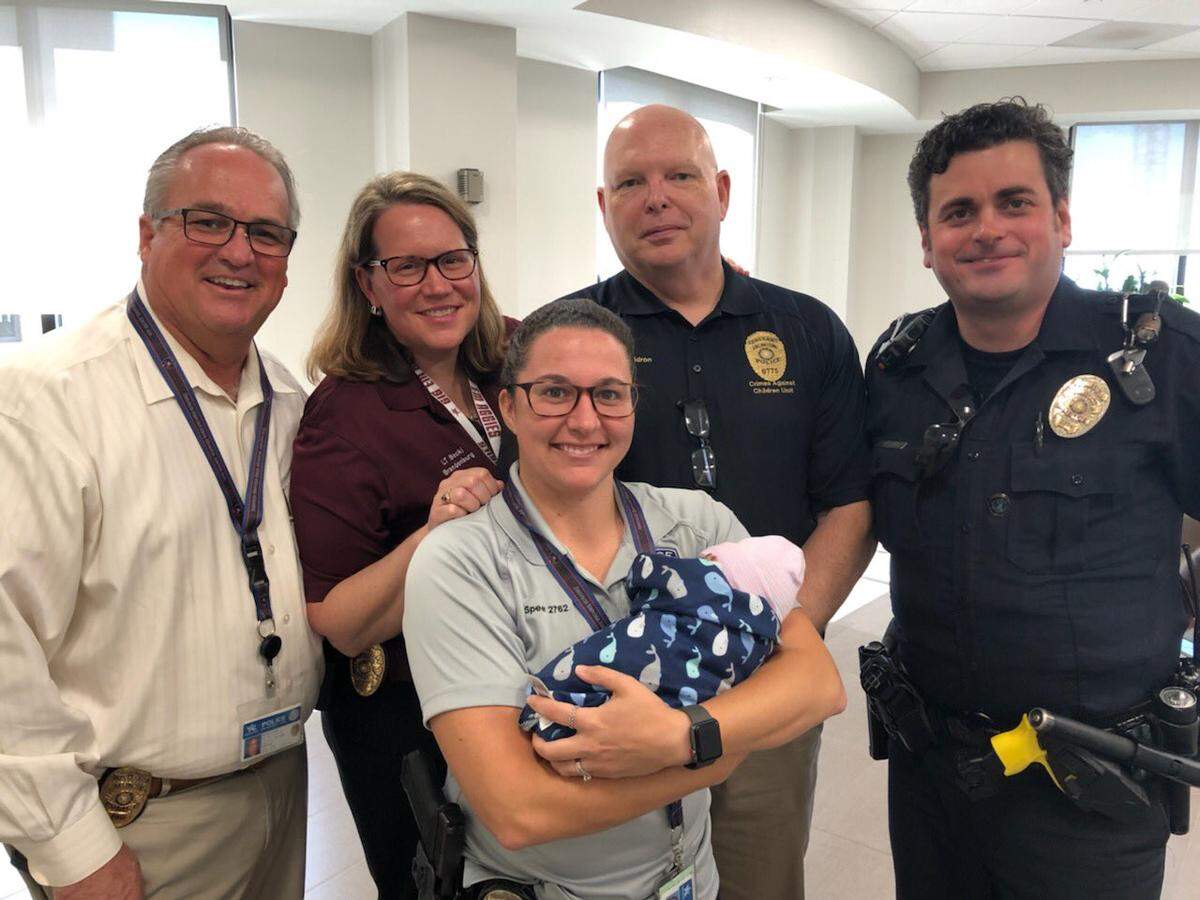 Arlington police officers pose with baby “Jason,” who was found inside of a suitcase near a dumpster nearly two weeks ago. Officers gave him the unofficial name Jason, police said, and he’s been doing great.