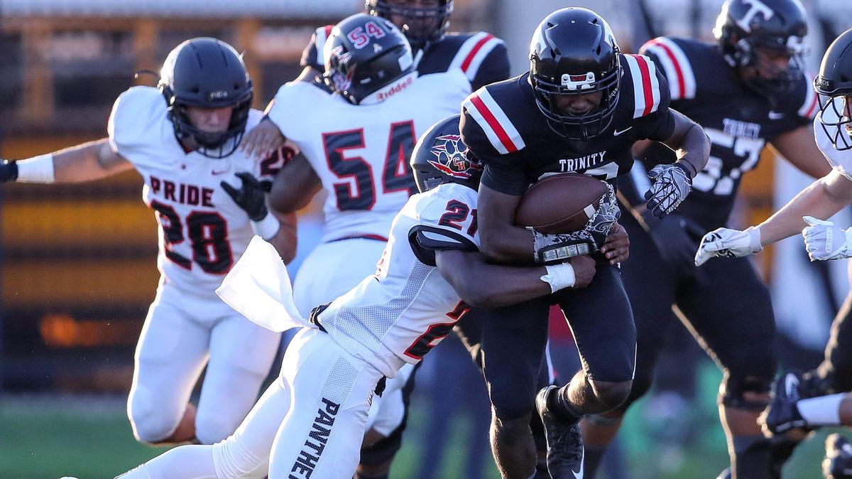 Trinity running back Malcolm Washington (28) is stopped by Colleyville Heritage defensive back Isaac Shabay (21) during the first half Thursday night at Pennington Field in Bedford.