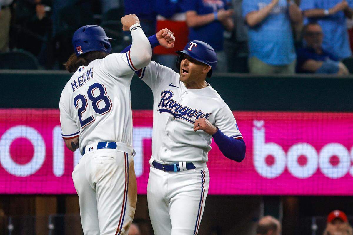 Rangers Jonah Heim and Brad Miller celebrate after Miller hit a home run during Rangers Opening Day ceremonies on March 30, 2023, at Globe Life Field in Arlington. The Texas Rangers beat the Philadelphia Phillies 11-7.