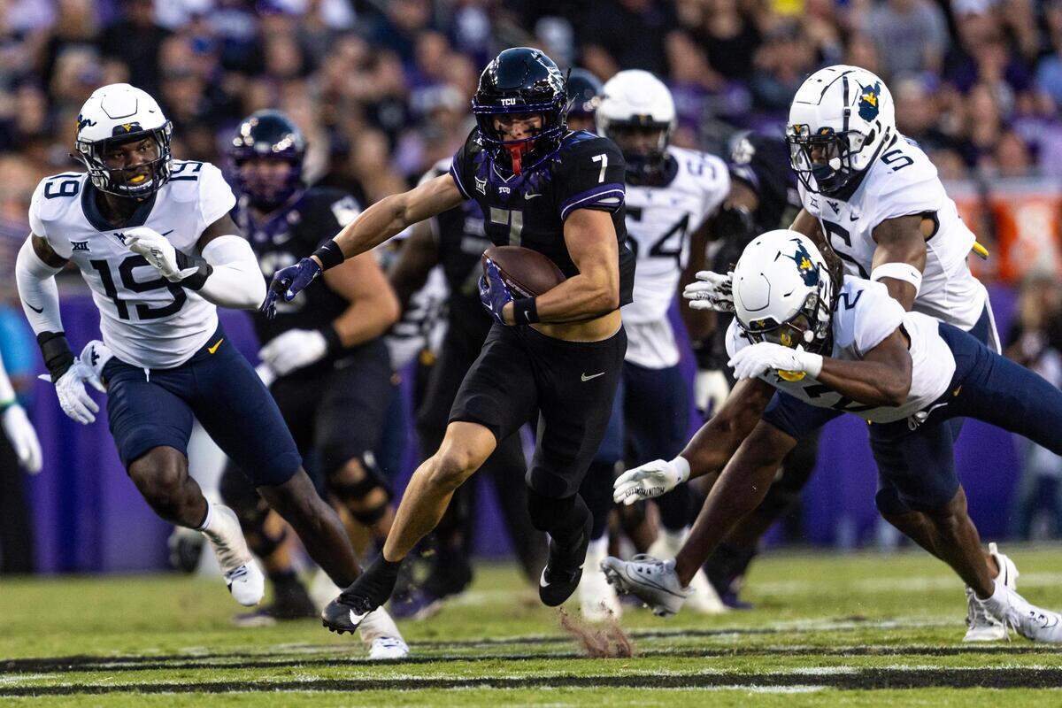 TCU wide receiver JP Richardson (7) evades West Virginia defenders on his way to score a touchdown in the first quarter of a Big XII conference game between the TCU Horned Frogs and the West Virginia Mountaineers at Amon G. Carter Stadium in Fort Worth on Saturday.