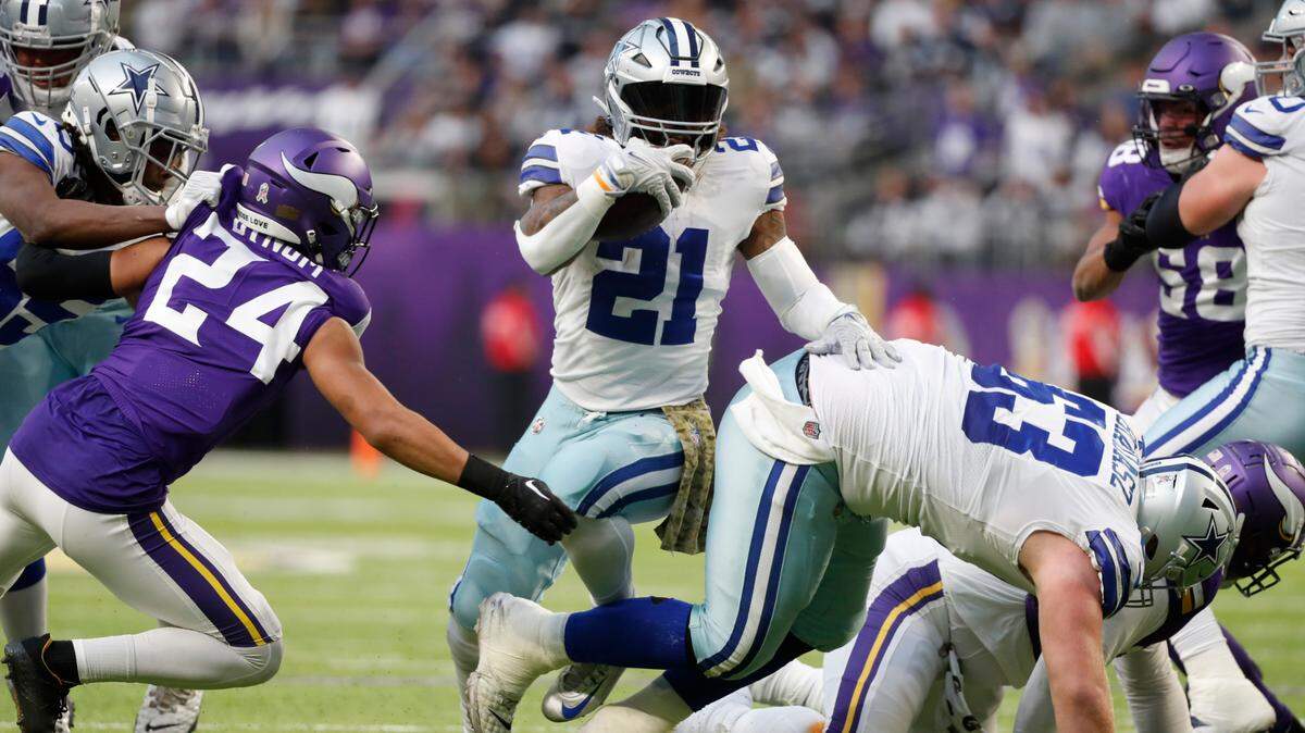 Dallas Cowboys running back Ezekiel Elliott (21) runs from Minnesota Vikings safety Camryn Bynum (24) during the first half Sunday.