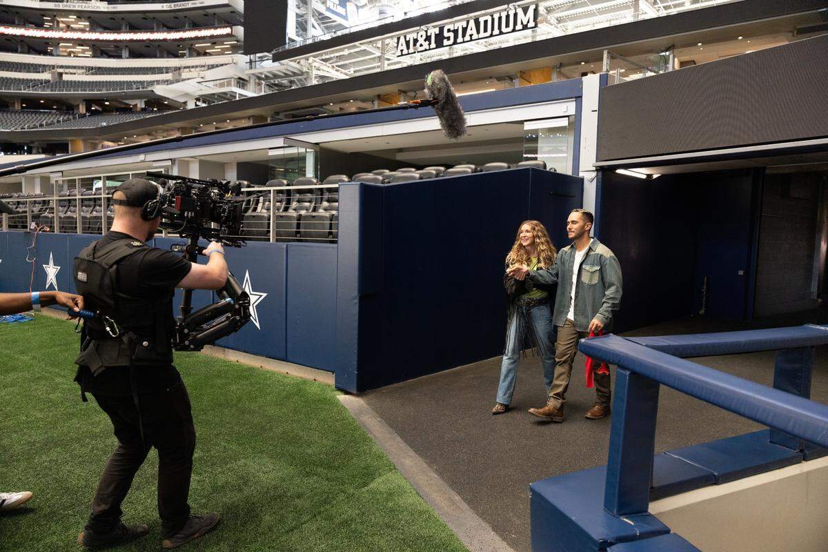 “Love at the Kettle” stars Alexa and Carlos PenaVega filming a scene at AT&T Stadium on Aug. 5, 2024.