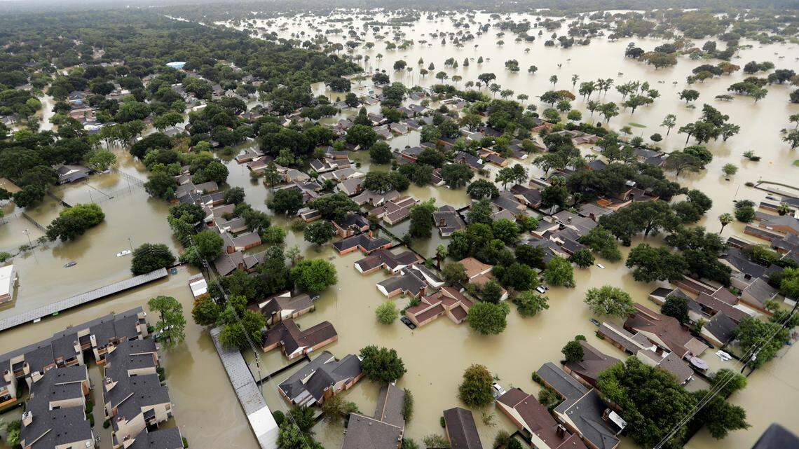 In this photo from Aug. 29, 2017, water from Addicks Reservoir flows into neighborhoods as floodwaters from Hurricane Harvey rise in Houston. Authorities say a man defrauded the American Red Cross out of over $46,000 meant for hurricane victims. He recently pleaded guilty.