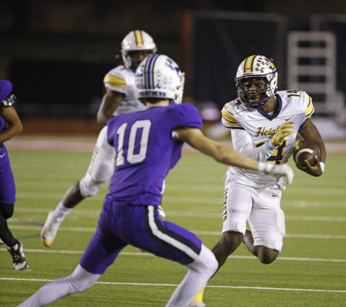 Arlington Heights quarterback Carmelo Carter (14) attempts to round the left corner during the first half of a UIL football game between Arlington Heights and Paschal at Farrington Field in Fort Worth, Texas, Friday Nov. 07, 2025.