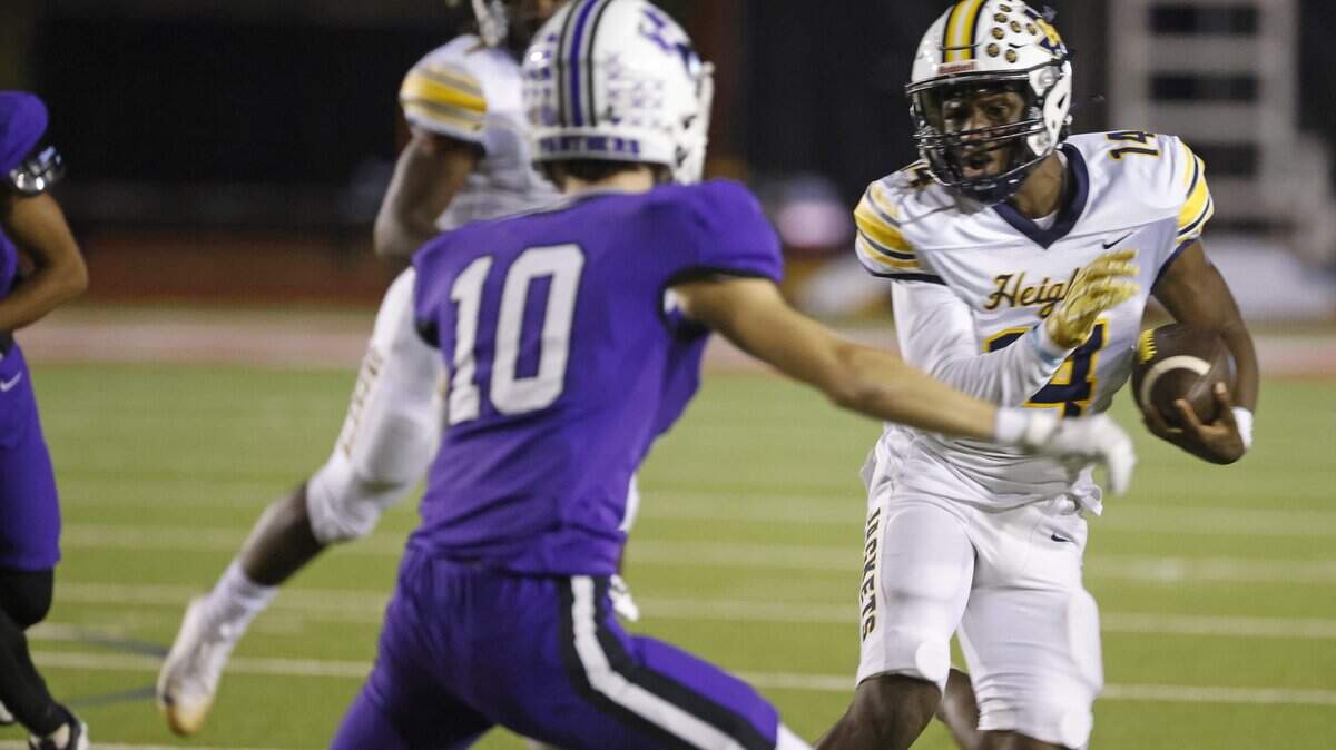 Arlington Heights quarterback Carmelo Carter (14) attempts to round the left corner during the first half of a UIL football game between Arlington Heights and Paschal at Farrington Field in Fort Worth, Texas, Friday Nov. 07, 2025.