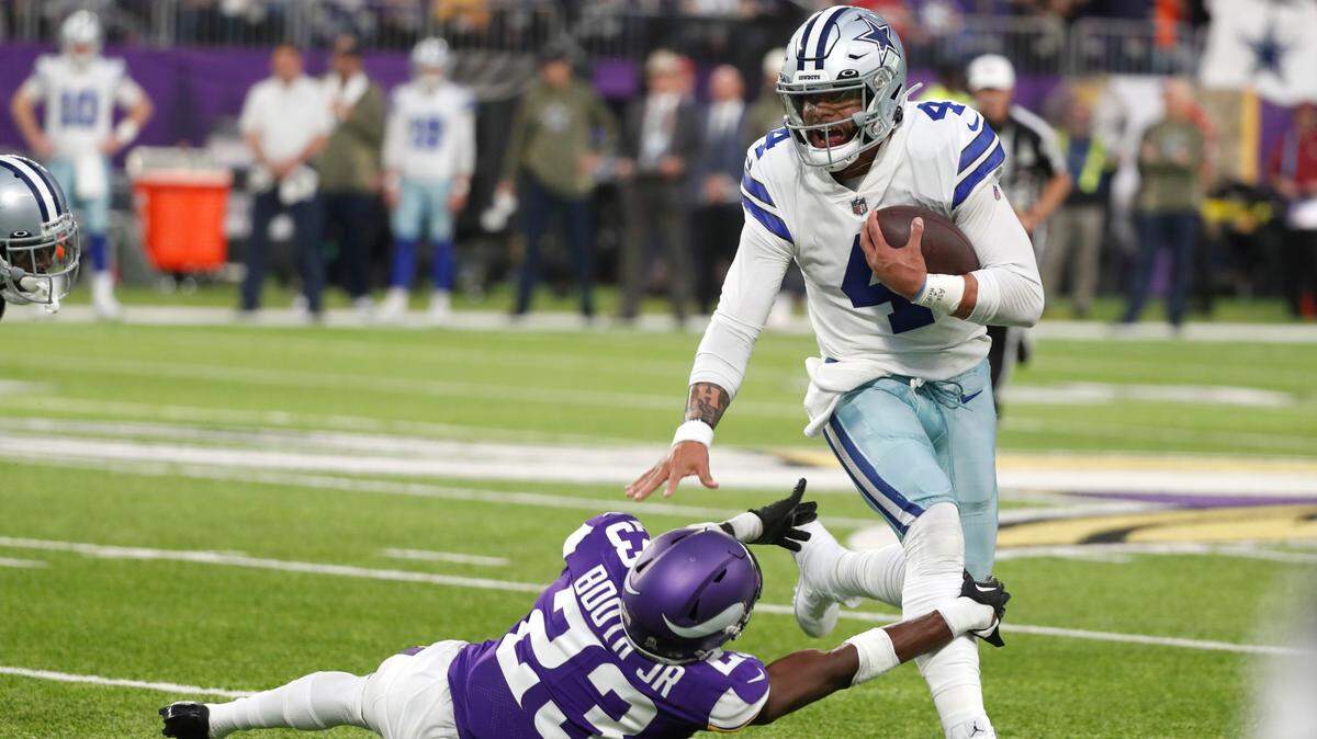Dallas Cowboys quarterback Dak Prescott (4) breaks a tackle by Minnesota Vikings cornerback Andrew Booth Jr. (23) during the first half of Sunday's game against the Vikings. 