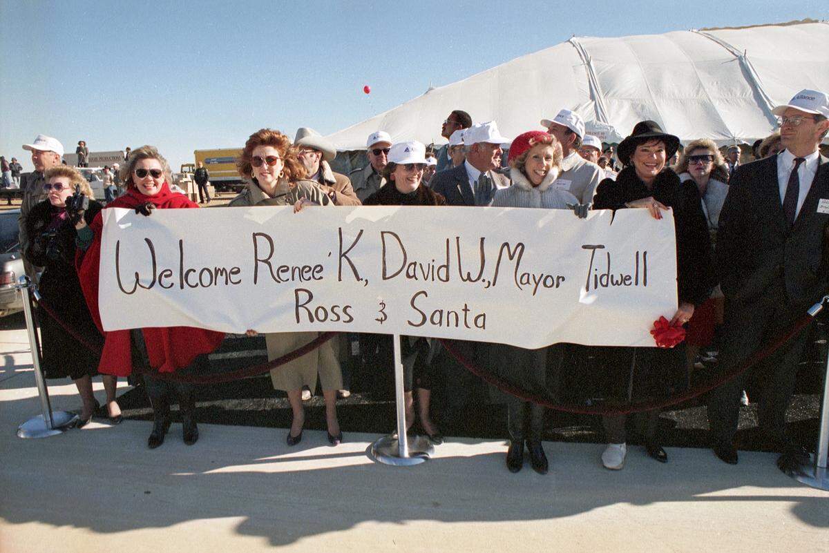 Dec. 14, 1989: The crowd at the inauguration ceremonies for the new $35 million Alliance Airport in Fort Worth include these women holding a sign for an arriving American Airlines Boeing 757, the first aircraft to land here. The names on their sign include Roanoke Mayor John Tidwell and Alliance Airport developer Ross Perot Jr. A Santa Claus was also on board.