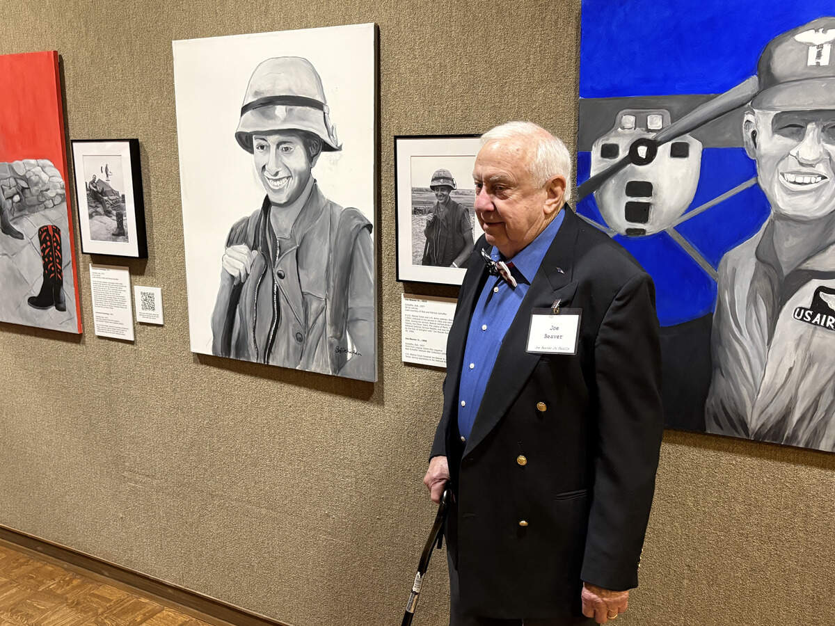 Marine Cpl. Joe Beaver Jr., of Arlington, stands next to journalist Bob Schieffer’s painting of him based on a photo he took of Beaver in Vietnam.