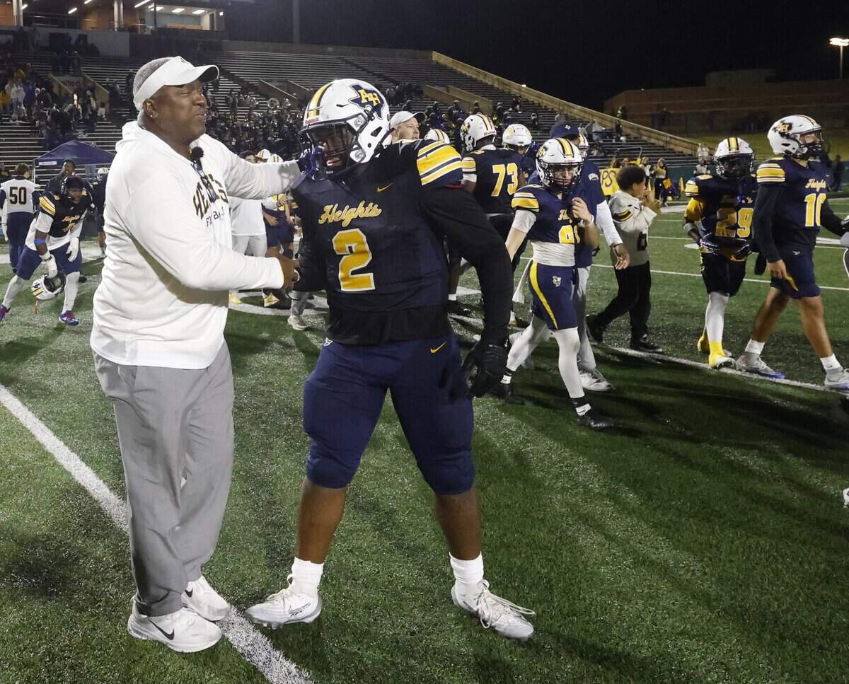 Fort Worth Arlington Heights head coach Curtis James congratulates one of his sons, defensive lineman Carter James (2), after the UIL Class 5A DI area-round football playoff game against Lubbock Monterey Thursday, Nov. 20, 2025, at Shotwell Stadium in Abilene, Texas.