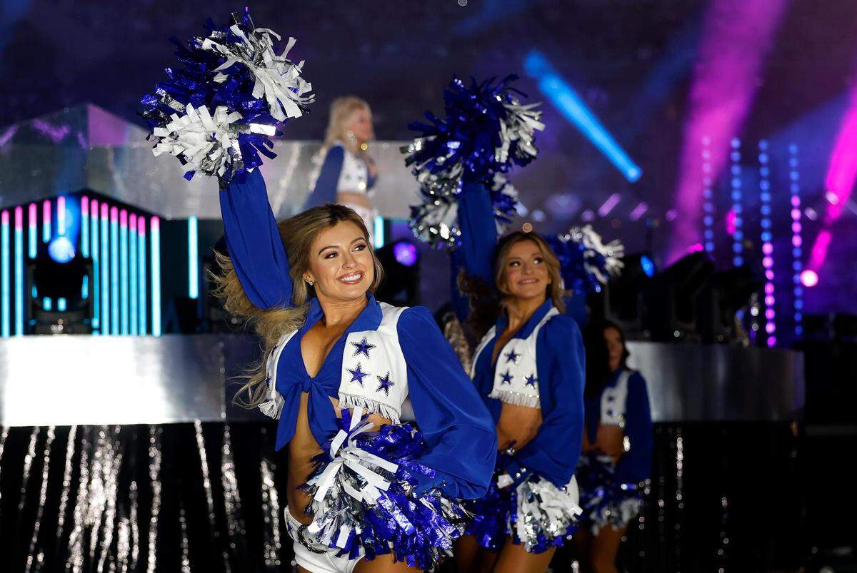The Dallas Cowboys Cheerleaders perform with Dolly Parton during the Dallas Cowboys’ halftime show to kickoff the Red Kettle Campaign on Thursday, November 23, 2023, at AT&T Stadium in Arlington.
