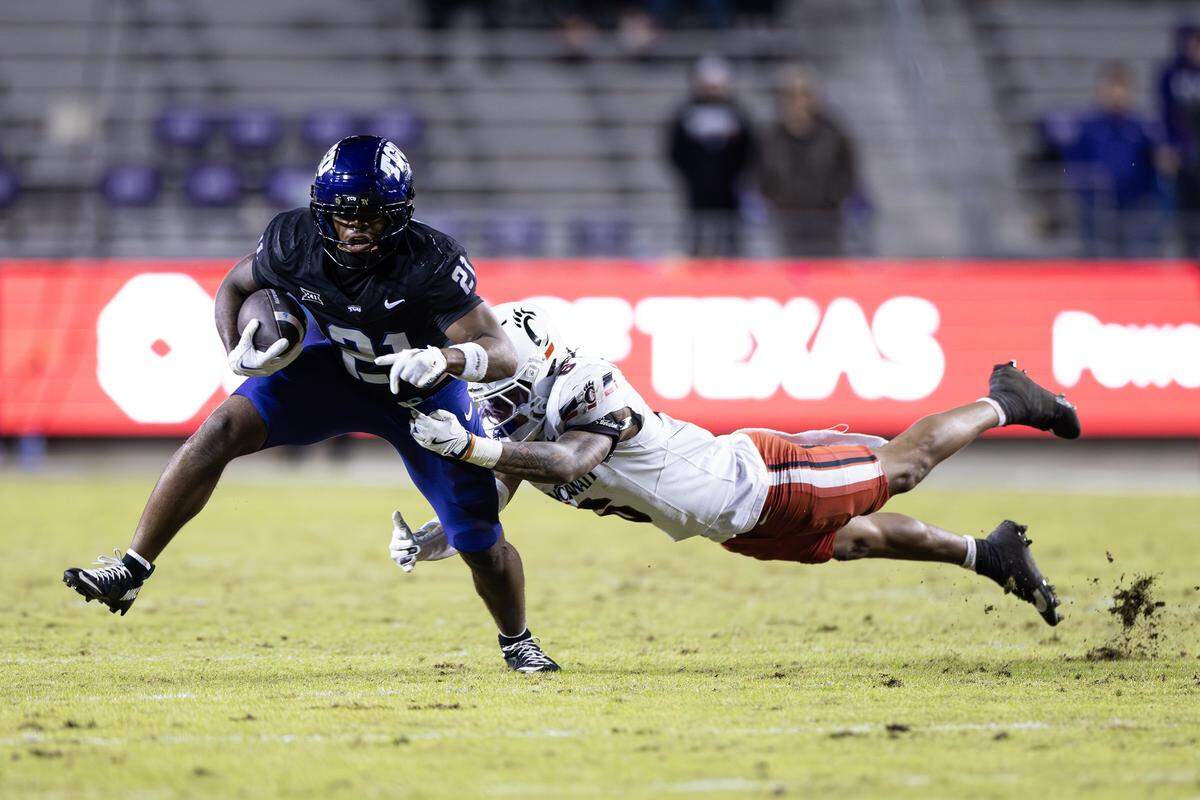 TCU running back Nate Palmer (21) drags a defender with him on a rush attempt in the second half of a Big XII conference game between the TCU Horned Frogs and the Cincinnati Bearcats at Amon G Carter Stadium in Fort Worth on Saturday, Nov. 29, 2025.