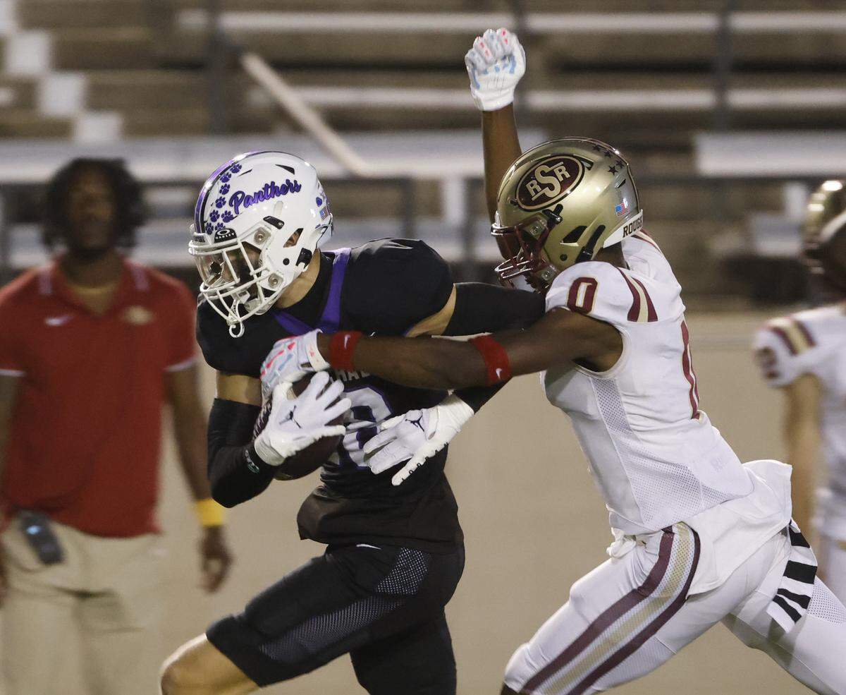 Saginaw defensive end Isaac Bukasa (0) attempts to strip the ball from Paschal wide receiver Hudson Avery (18) during the first half of a UIL football game between Saginaw and Paschal at Farrington Field in Fort Worth, Texas, Thursday, October, 16, 2025.