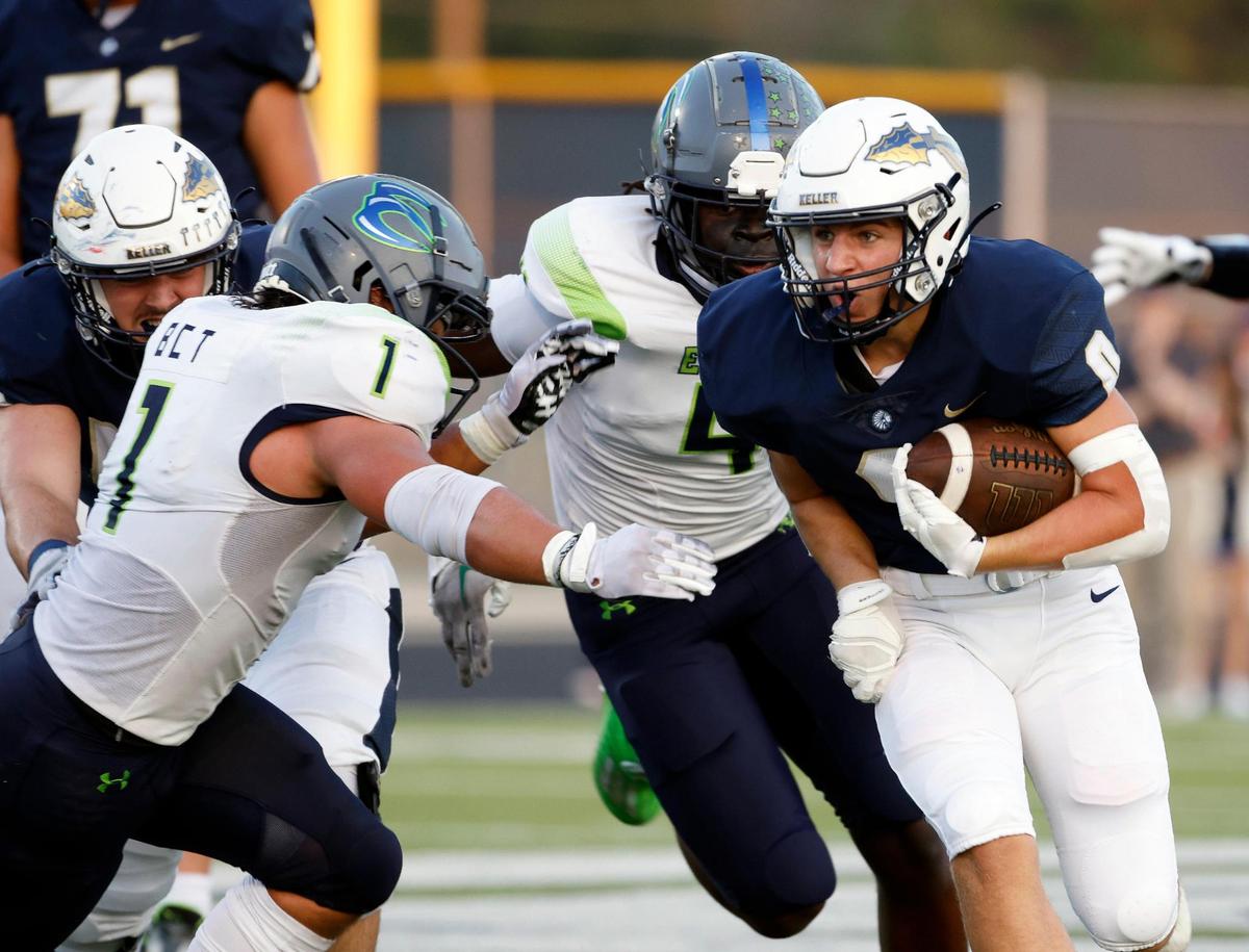 Keller running back Kyle Owens (0) runs into the defense of Eaton linebacker Joseph Frazier (1) in the first half of a UIL high school football game at Keller ISD Stadium in Keller, Texas, Friday, Sept. 15, 2023. Keller led Eaton 31-14 at the half.