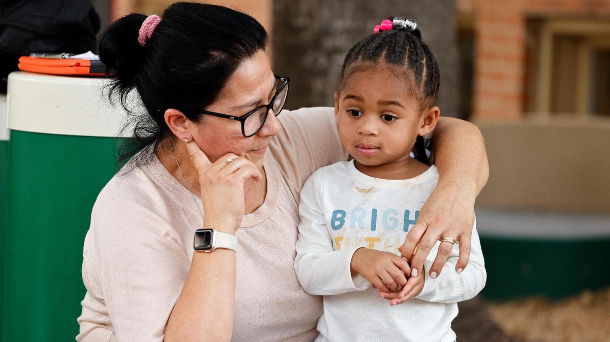 Preschool teacher Elsa Burris talks with a child during a play period at the Rosie K. Mauk Child Development Center in Fort Worth on Wednesday.