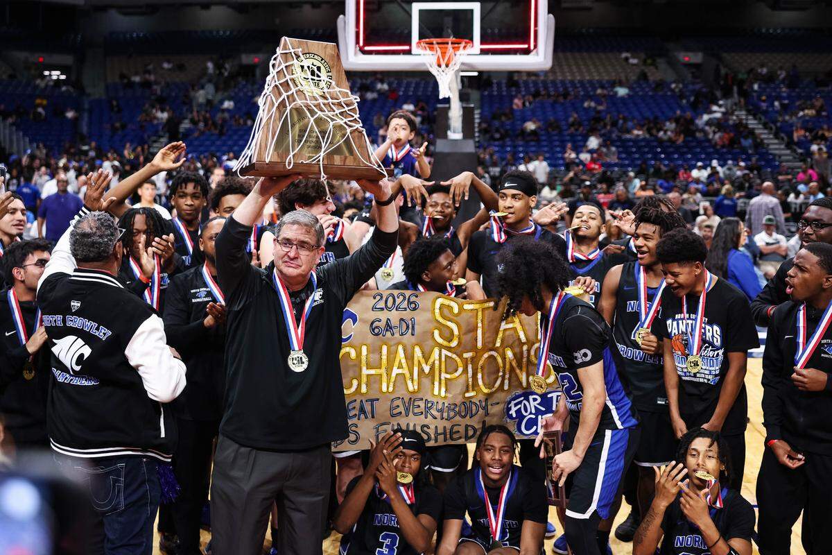 North Crowley head coach Tommy Brakel emotionally hoists the championship trophy after the Class 6A Division I state title game against San Antonio Brennan on Saturday at the Alamodome in San Antonio.