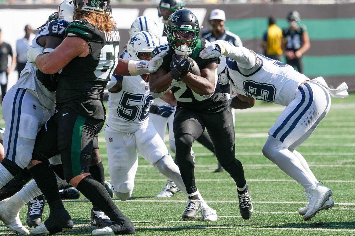 Oct 5, 2025; East Rutherford, New Jersey, USA; New York Jets running back Breece Hall (20) carries the ball as Dallas Cowboys defensive tackle Perrion Winfrey (99) defends during the first half at MetLife Stadium. Mandatory Credit: Robert Deutsch-Imagn Images