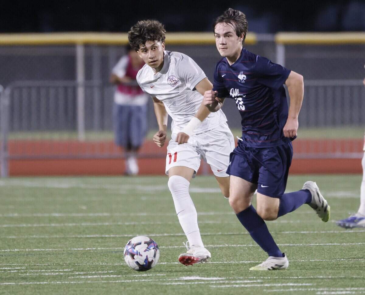Allen midfielder Hudson Crook (13) brings the ball in front of Arlington Sam Houston Edson Morin (11) during the first half of a UIL area round boys soccer playoff game at Tommy Standridge Stadium in Carrollton, Texas, Tuesday, March 24, 2026.